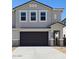 Two-story home features a gray stucco exterior, dark brown garage door and modern architectural details at 1123 E Mcneil St, Phoenix, AZ 85042