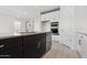 Modern kitchen island with stainless steel sink and appliances, light countertops and gray backsplash at 1123 E Mcneil St, Phoenix, AZ 85042