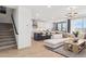 Open-concept living room featuring modern decor, a staircase, and a view into the kitchen at 1123 E Mcneil St, Phoenix, AZ 85042