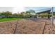 Sand volleyball court surrounded by green grass and featuring a shaded picnic area at 1123 E Mcneil St, Phoenix, AZ 85042