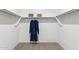 A walk-in closet with simple shelving and a rod, offering ample storage space with carpeted flooring at 1123 E Mcneil St, Phoenix, AZ 85042