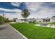 A lush backyard featuring a pool, outdoor kitchen, and well-manicured lawn at 12209 N 66Th St, Scottsdale, AZ 85254