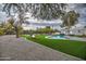 Expansive backyard with a sparkling pool, verdant lawn, and inviting lounge areas at 12209 N 66Th St, Scottsdale, AZ 85254