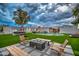 Expansive backyard featuring a pool, outdoor kitchen, grass area, and lounge furniture at 12209 N 66Th St, Scottsdale, AZ 85254