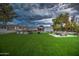 Expansive backyard featuring lush lawn, an outdoor kitchen, fire pit, built-in grill, and ample seating for entertaining at 12209 N 66Th St, Scottsdale, AZ 85254