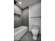 Modern bathroom with a bathtub, gray tiled shower, and a sleek toilet with coordinated fixtures at 12209 N 66Th St, Scottsdale, AZ 85254