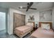 Comfortable bedroom featuring two beds, artistic wall decor, and a rustic sliding closet door at 12209 N 66Th St, Scottsdale, AZ 85254