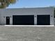 Exterior view of a three car garage with black doors at 12209 N 66Th St, Scottsdale, AZ 85254