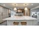 Beautiful kitchen boasts a large center island with seating, custom cabinets, and designer lighting at 12209 N 66Th St, Scottsdale, AZ 85254