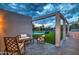 Stylish outdoor seating area overlooking a lush backyard with a pool, outdoor kitchen, and manicured landscaping at 12209 N 66Th St, Scottsdale, AZ 85254