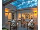 Cozy patio with stylish outdoor seating, featuring cushioned chairs and a wooden table, with warm lighting at 12209 N 66Th St, Scottsdale, AZ 85254