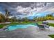 Inviting pool with a serene patio, outdoor kitchen, lush lawn, and elegant landscaping for an entertainer's dream backyard at 12209 N 66Th St, Scottsdale, AZ 85254