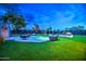 Beautiful backyard showcasing a sparkling pool, outdoor seating, lush artificial turf, and a built-in bar area at 12209 N 66Th St, Scottsdale, AZ 85254