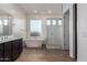 Bathroom featuring a soaking tub, glass shower, double sink and wood-look flooring at 13653 W Crabapple Dr, Peoria, AZ 85383