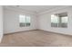 Spacious bedroom with carpet, tray ceiling, and ample natural light from two large windows at 13653 W Crabapple Dr, Peoria, AZ 85383