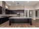 Modern kitchen with stainless steel appliances, dark cabinetry, large island, and stylish backsplash at 13653 W Crabapple Dr, Peoria, AZ 85383