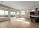 Spacious living room with wood floors, large windows, and an open floor plan to the kitchen at 13653 W Crabapple Dr, Peoria, AZ 85383