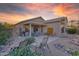 Charming backyard featuring a private patio, desert landscaping and lovely sunset at 15848 W Lahlum Ln, Surprise, AZ 85374