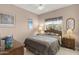 Comfortable bedroom with neutral paint, wooden furnishings, a ceiling fan, and a window with natural light at 15848 W Lahlum Ln, Surprise, AZ 85374