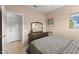 This cozy bedroom features soft peach paint, wooden dresser with mirror, carpeted floors, and natural light at 15848 W Lahlum Ln, Surprise, AZ 85374