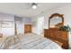 Spacious bedroom featuring soft lilac accent wall, wooden furnishings, carpeted entryway, and natural light at 15848 W Lahlum Ln, Surprise, AZ 85374