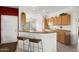 Functional kitchen featuring a breakfast bar, white appliances, and ample cabinet space perfect for cooking at 15848 W Lahlum Ln, Surprise, AZ 85374