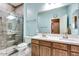 Bathroom featuring a walk-in glass shower and a double sink vanity with wood cabinets at 16026 N 171St Ln, Surprise, AZ 85388