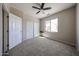 A clean bedroom featuring a ceiling fan, natural light, and closet at 16137 W Quail Creek Ln, Surprise, AZ 85374