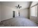 A spacious bedroom boasts neutral colors, a ceiling fan, and convenient access to other rooms at 16137 W Quail Creek Ln, Surprise, AZ 85374