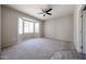 This bedroom features neutral colors, a ceiling fan, and a bay window allowing ample natural light at 16137 W Quail Creek Ln, Surprise, AZ 85374