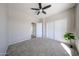Bright bedroom featuring plush carpeting, a ceiling fan, and a convenient closet with sliding doors at 16137 W Quail Creek Ln, Surprise, AZ 85374