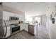 Modern kitchen featuring stainless steel appliances, white cabinetry, and sleek countertops at 16137 W Quail Creek Ln, Surprise, AZ 85374