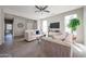 Comfortable living room with plush sofas, neutral decor, and a mounted television at 16137 W Quail Creek Ln, Surprise, AZ 85374