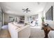 Open-concept living room boasts neutral tones, ceiling fan, and seamless transition to the adjacent dining and kitchen areas at 16137 W Quail Creek Ln, Surprise, AZ 85374