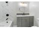 Modern bathroom features a gray vanity, gold accents, and marble tile in the shower at 1642 E Turney Ave, Phoenix, AZ 85016