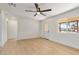 A bright living room with wood floors, white walls, modern ceiling fan and natural light at 1642 E Turney Ave, Phoenix, AZ 85016