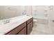 Bathroom features white countertop vanity, undermount sink, tile floors, and a shower-tub combination at 16721 W Whispering Wind Dr, Surprise, AZ 85387