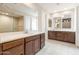 Bathroom featuring double vanities with stone countertops, framed mirrors and walk-in shower at 16721 W Whispering Wind Dr, Surprise, AZ 85387