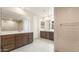 Bright bathroom featuring double vanities, framed mirrors, a glass shower and tile floors at 16721 W Whispering Wind Dr, Surprise, AZ 85387
