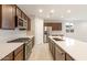 The kitchen features stainless steel appliances, shaker cabinets, and quartz countertops with a backsplash at 16721 W Whispering Wind Dr, Surprise, AZ 85387