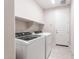 Laundry room features new white appliances and tile floor and door to the hallway at 16721 W Whispering Wind Dr, Surprise, AZ 85387
