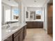 Bright bathroom features double sinks, dark wood cabinets, and large mirrors at 16735 W Whispering Wind Dr, Surprise, AZ 85387
