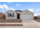 Charming single-story home featuring a two-car garage, stucco siding, and desert landscaping at 16735 W Whispering Wind Dr, Surprise, AZ 85387