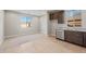 Bright kitchen showcasing ample counter space, stainless steel dishwasher, and neutral tile flooring at 16735 W Whispering Wind Dr, Surprise, AZ 85387