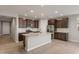 A kitchen featuring granite countertops, stainless steel appliances, and dark brown cabinetry in an open floor plan at 16735 W Whispering Wind Dr, Surprise, AZ 85387