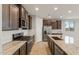 A kitchen featuring granite countertops, stainless steel appliances, and dark brown cabinetry with ample storage at 16735 W Whispering Wind Dr, Surprise, AZ 85387