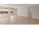 A large, bright living room with tile flooring, recessed lights, and access to the outdoor living space at 16735 W Whispering Wind Dr, Surprise, AZ 85387