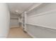 Spacious walk-in closet with carpeted floors, shelving, and hanging rods at 16735 W Whispering Wind Dr, Surprise, AZ 85387