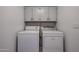 Functional laundry room with washer, dryer, overhead cabinets, and neutral tile flooring at 1699 Leisure World --, Mesa, AZ 85206