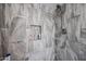 The walk-in shower is encased with decorative stone, a shower caddy and rain shower fixture at 1699 Leisure World --, Mesa, AZ 85206